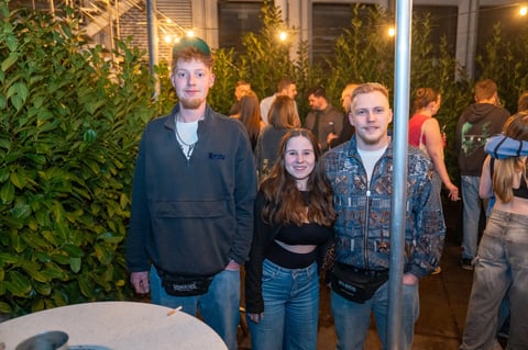Three young people with greenery