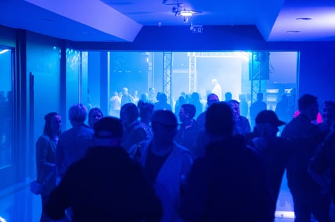 Group of people silhouetted in a blue-lit room